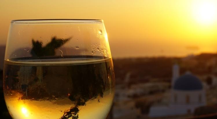 Enjoying Santorinian Wine during Sunsetas a Solo Traveler